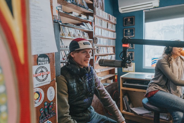 Student recording in radio sound booth